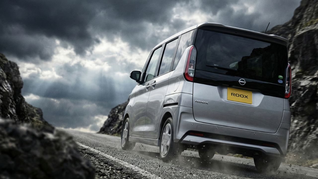 曇り空の下、急な坂道を走行する軽自動車の後ろ姿。加速性能への不安を象徴するシーン